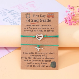Detail of dinosaur heart charm woven bracelets on a decorative backcard for 2nd Grade