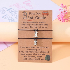 Detail of 3rd grade back to school woven bracelets with dinosaur charms on card