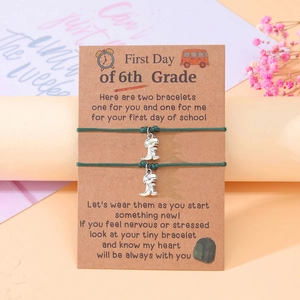 Detailed view of dark green dinosaur bracelets on brown greeting card for back to school