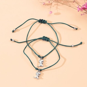 Detail view of two adjustable green woven dinosaur charm bracelets for students