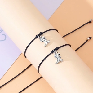 Close-up of adjustable black braided ropes with silver 3D dinosaur pendants