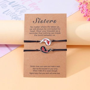 Vista dettagliata dei braccialetti dell'amicizia Yin-Yang Koi su carta regalo Sisters.
