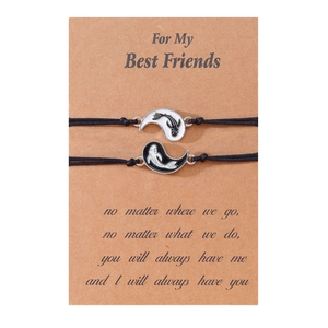 Dettaglio di braccialetti dell'amicizia con ciondoli yin yang su carta da regalo