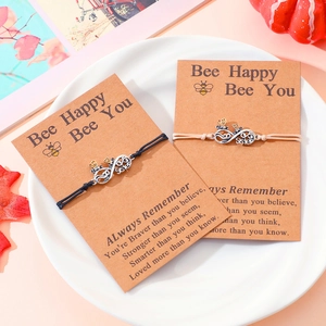 Friendship bracelets with infinity symbols and bee charms on motivational cards