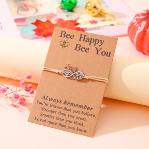 Detail of bee infinity charm on hand-woven friendship bracelet with sister gift card