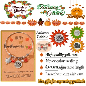 Detail of stainless steel charm bracelet with maple leaf and holiday pendants on orange card