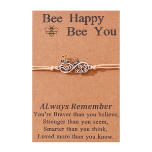Detail of bee infinity bracelet on kraft card with Sister engraving and quote