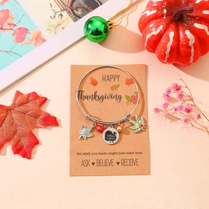 Detail of Thanksgiving charm bracelet with turkey pendant and maple leaves on display card