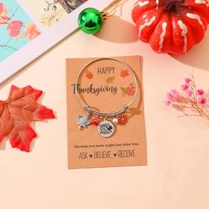 Adjustable stainless steel Thanksgiving charm bracelet with maple leaf and bead on a gift card