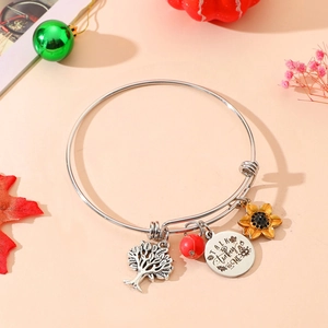 Detail of silver bangle with Tree of Life, sunflower and Talk Turkey To Me pendants