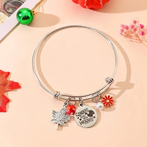 Detail of adjustable silver bracelet with maple leaf, turkey charm and pearls
