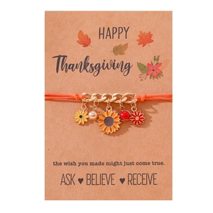 Pulsera de Acción de Gracias tejida en naranja con girasoles y dijes en tarjeta