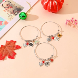 Detailed view of Thanksgiving charm bracelets with turkey, maple leaf and sunflower pendants