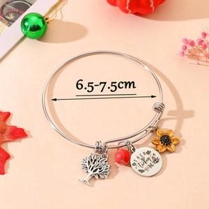 Detail of adjustable stainless steel bangle with tree of life and turkey pendants
