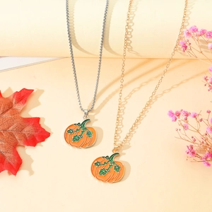 Dettaglio della collana con ciondolo a zucca e acero con smalto arancione e accenti autunnali