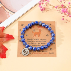 Detail eines blauen Steinarmbands mit Edelstahl-Hundeanhänger auf einer Geschenkkarte