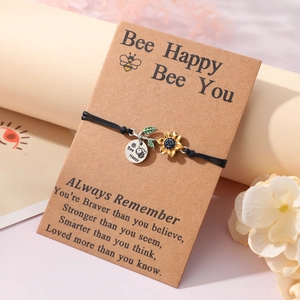 Detail of bee happy sunflower charm bracelet on inspirational kraft card with black cord
