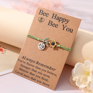 Handmade green rope bracelet with sunflower charm and Bee Happy tag on card packaging