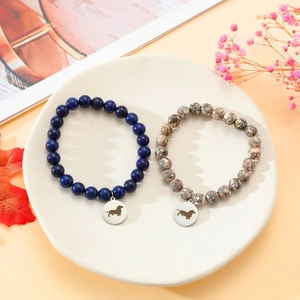 Nahaufnahme von Steinperlenarmbändern mit Dackel-Anhängern aus Edelstahl auf einem Steintablett