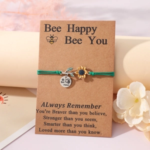 Detail of woven bracelet with sunflower charm and Bee Happy engraved tag on card