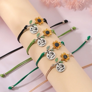 Detailed view of woven sunflower bracelets featuring Bee Happy engraved metal charms