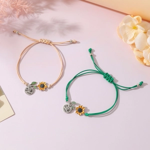 Detail of adjustable braided bracelets with bee happy charm and sunflower pendant
