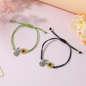 Detail of adjustable sunflower bracelets with Bee Happy bee pendants on soft background