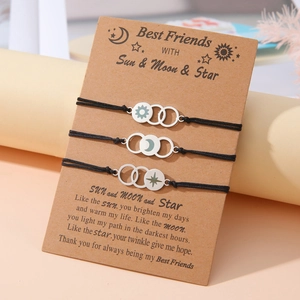 Detail of sun moon and star charms on adjustable black woven friendship bracelets set