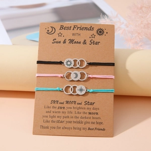 Detailed view of sun moon and star charms on braided friendship bracelets with card