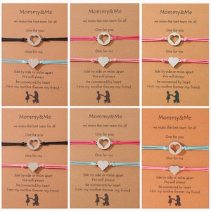 Detalle de colgantes de corazón hueco en pulseras para madre e hija con tarjeta