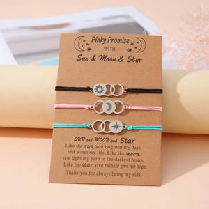 Three-piece set of woven friendship bracelets with sun, moon, and star metal charms