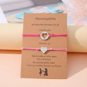 Detalle de las pulseras de corazón Mommy & Me en una tarjeta decorativa de cartón kraft
