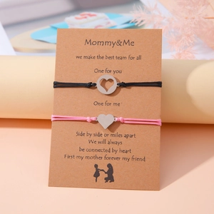 Detalle de las pulseras para madre e hija con dije de corazón en tarjeta de regalo