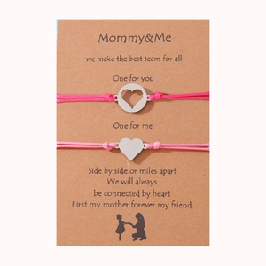 Detalle de pulseras rosa Mommy and Me con dijes de corazón en una tarjeta con poema