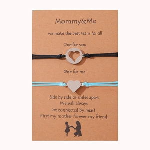 Detalle de las pulseras corazón Mommy & Me trenzadas en negro y azul en tarjeta