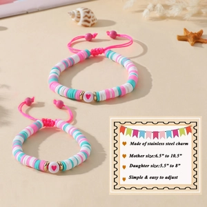 Détail de bracelets en perles d'argile rose et bleu avec pendentif cœur et guide de taille