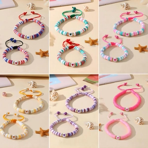 Détail de bracelets en perles Heishi colorées avec breloques cœur dans un style plage