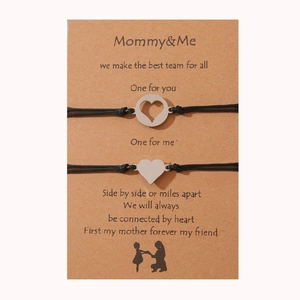 Detalle de las pulseras para madre e hija con colgantes de corazón en tarjeta de regalo