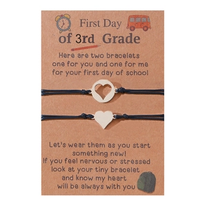 Two-piece heart charm adjustable braided bracelet set on a kraft display card