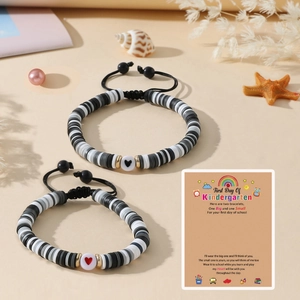 Détail de bracelets faits main avec perles heishi et cœur sur une carte cadeau scolaire