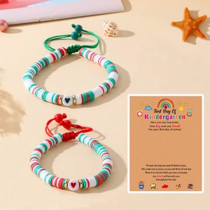 Détail de deux bracelets faits main en perles d'argile avec motifs cœur et carte cadeau