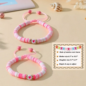 Détail du bracelet mère-fille en perles heishi roses et blanches avec breloque cœur