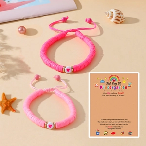 Bracelets en perles d'argile rose avec cœur sur carte cadeau Premier jour de maternelle