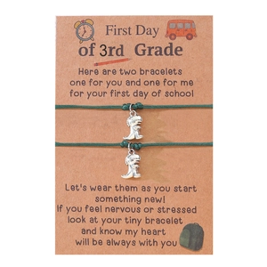 Green woven bracelets with dinosaur pendants for parent and child on third grade card