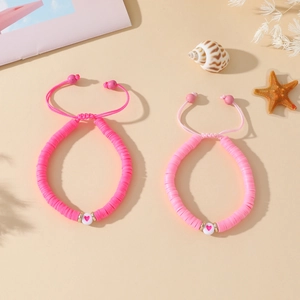 Gros plan de bracelets Heishi en pâte polymère rose avec cordon tressé réglable