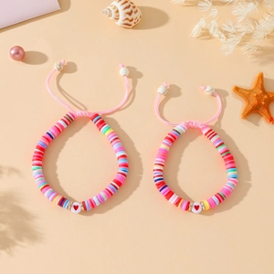 Détail de bracelets cœur en argile polymère colorée avec cordons roses réglables pour maman et fille
