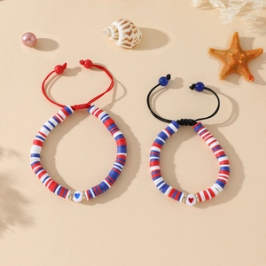 Détail de bracelets bohèmes faits main avec perles Heishi et breloque en cœur