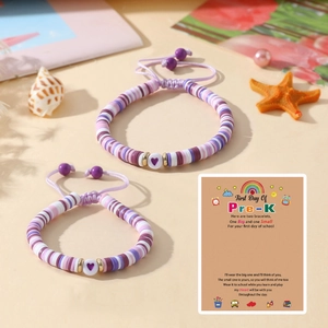 Détail de bracelets perlés mère fille avec breloques cœur sur carte de vœux Pre-K