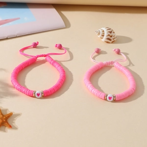 Détail de bracelets faits main en argile polymère avec cœurs et cordon rose ajustable