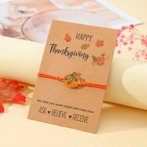 Handgewebtes Erntedankfest-Armband mit Kürbis-Anhänger auf einer Geschenkkarte